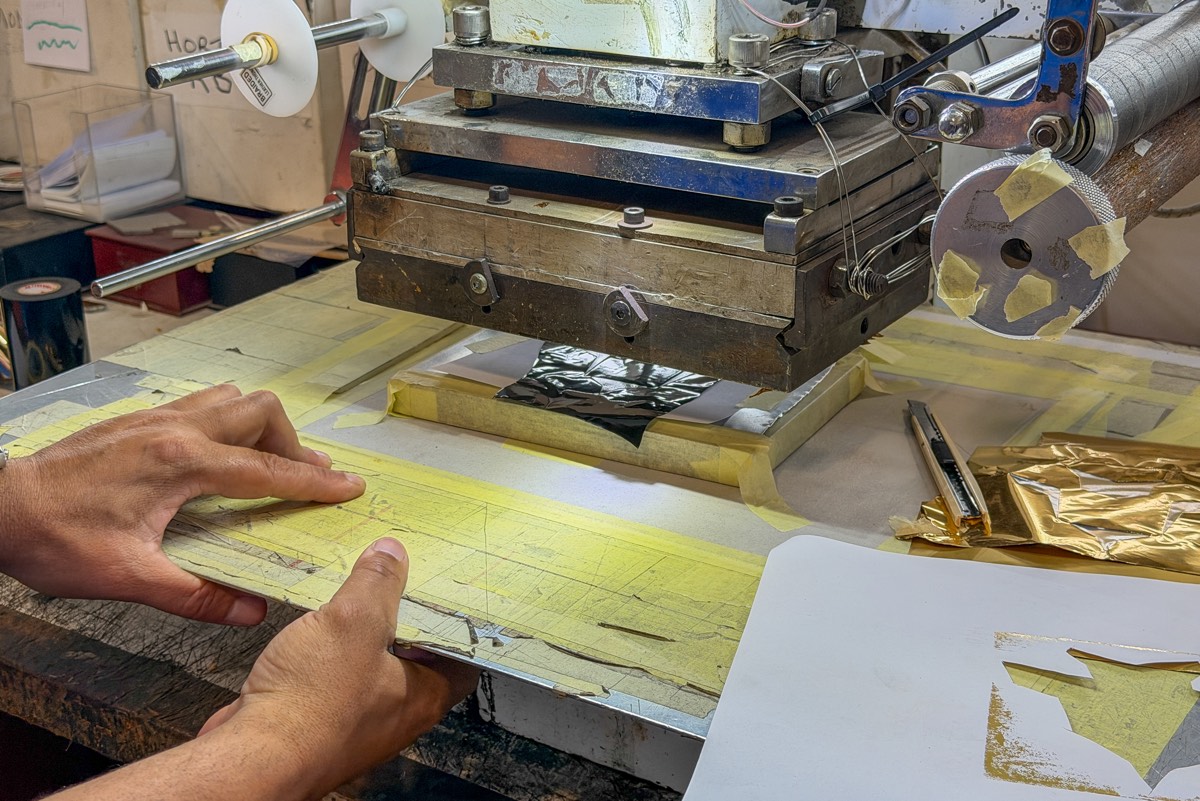 Hands loading a hot foil press