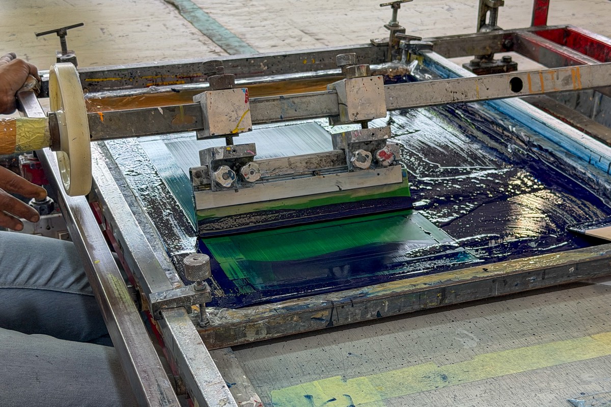 Silk screen press mid-pull